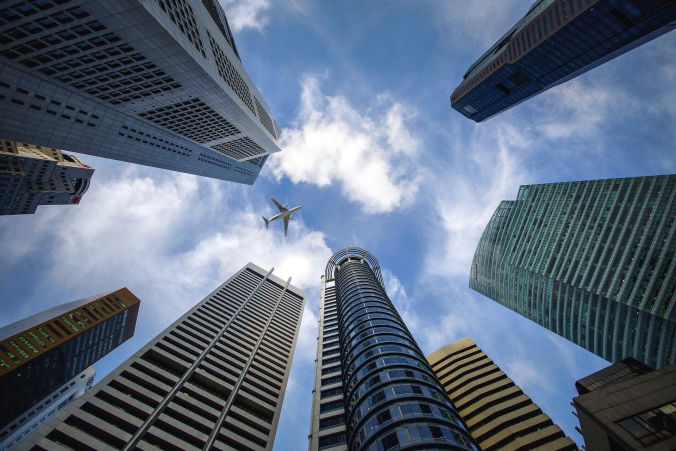 Photograph looking up into tall skyscrapers.