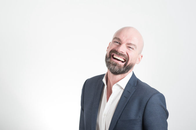 Image of a bearded happy man laughing.