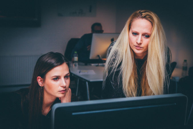 Two women looking at a computer screen.